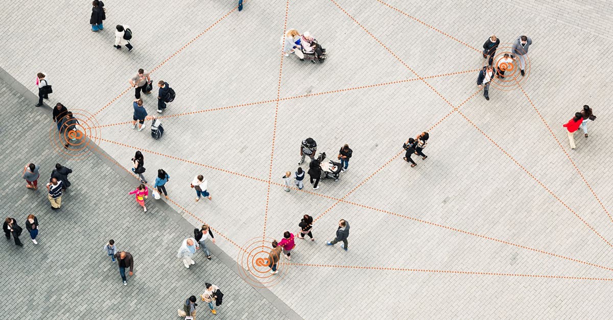 Menschen auf öffentlichem Platz mit GPS-Standortmarkierungen im Kontext der KEYCO-Markteinführung